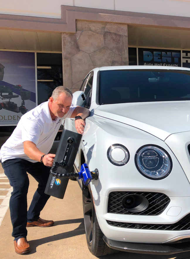 dent HQ mechanics checking hail damage of a white car